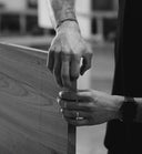 Close-up of hands holding a wooden stick with blurred background