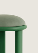 Close up of the premium fabric selection and rounded chestnut legs on the Juntowd Trio bespoke upholstered stool.
